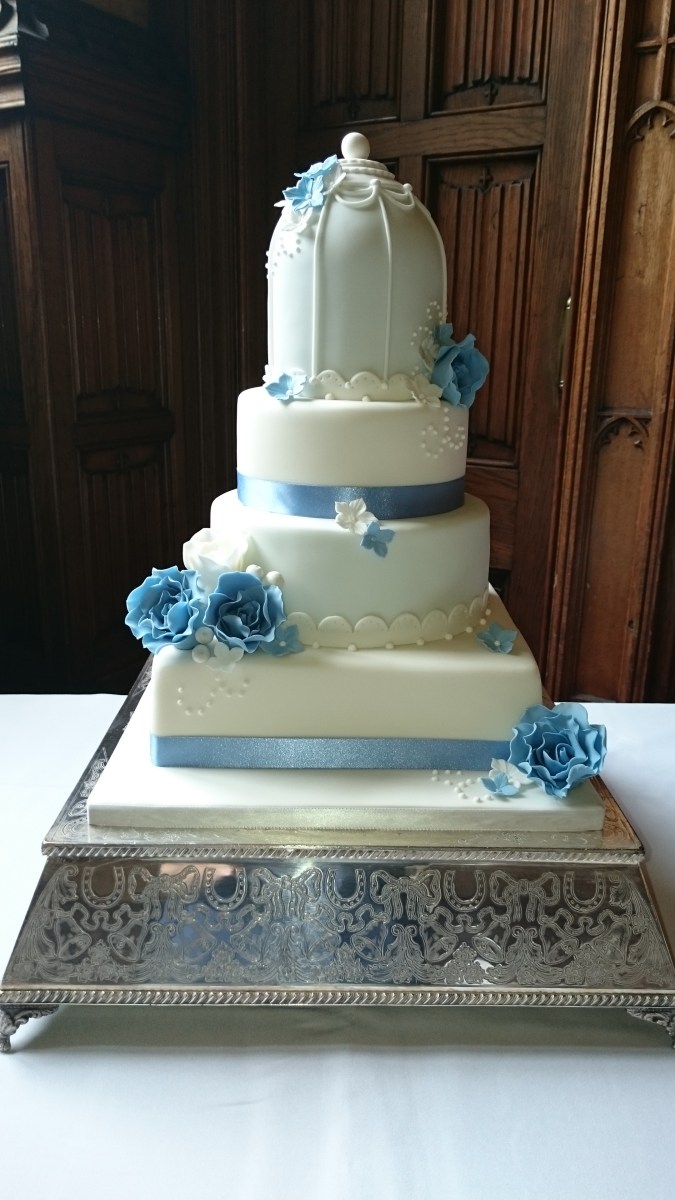 White and blue birdcage wedding cake with handmade sugar flowers
