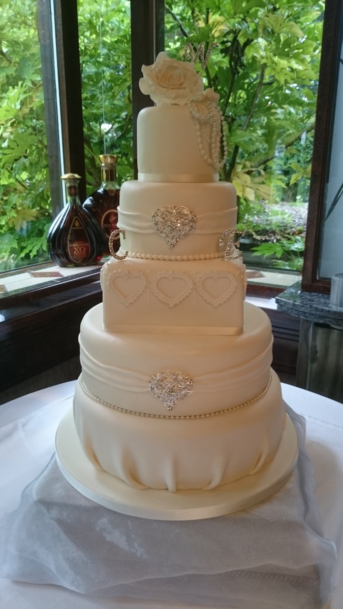 Elegant 5 tier ivory wedding cake with brooches