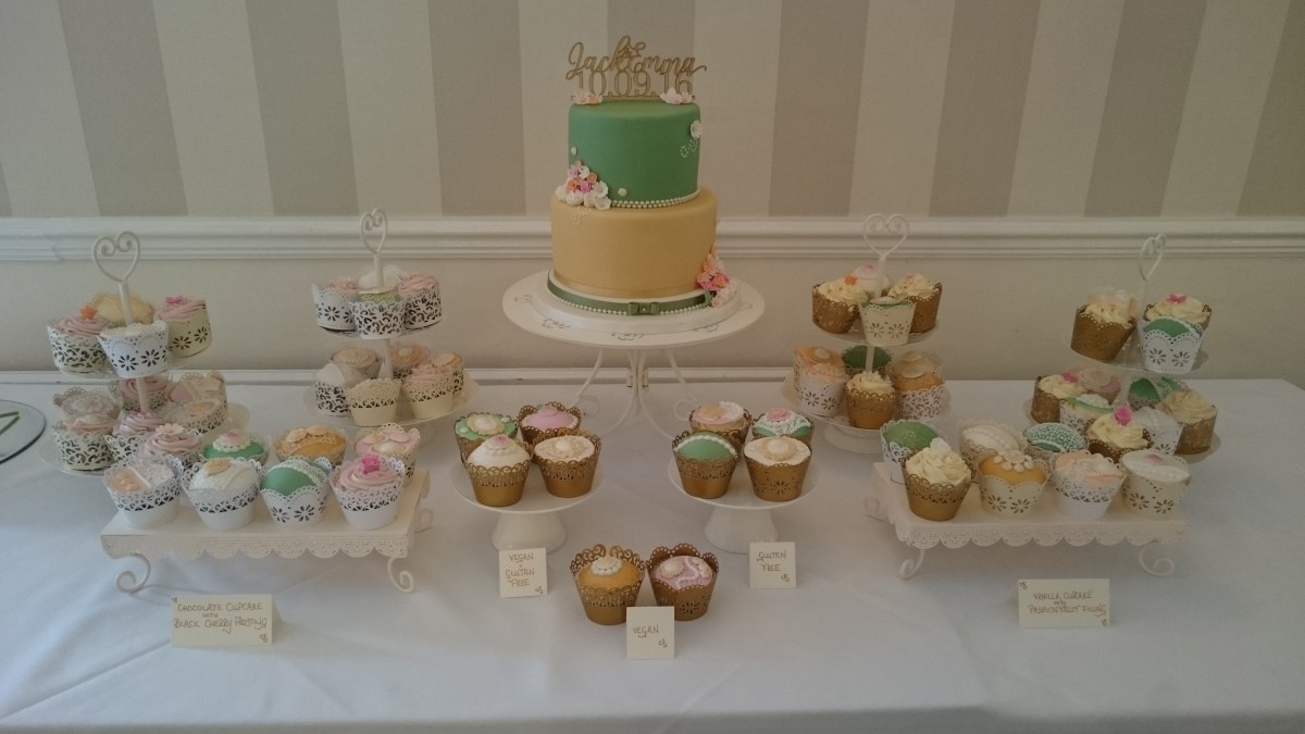 Green and gold wedding cake with cupcakes